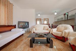 a living room with two couches and a tv at Guest House Moonlight in Ksamil