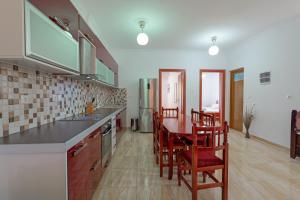 a kitchen with a table and some chairs in a room at Guest House Moonlight in Ksamil