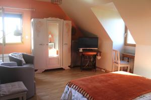 a room with a bed and a desk with a television at Chambre D'hotes Le Clos Fleuri in Criel-sur-Mer