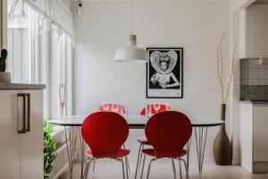 a kitchen with a dining room table with red chairs at Cozy townhouse 7 beds in Stockholm County in Kungsängen