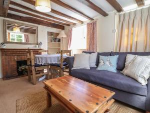 a living room with a blue couch and a table at 2 The Almshouses in Saxmundham
