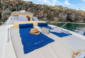 Una barca con due asciugamani blu e un cappello sopra. di Yacht Mea - Pantelleria a Pantelleria