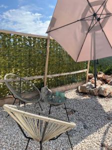 a chair and a table and an umbrella on a patio at Glamping ROSE (Luštica Bay) in Radovići
