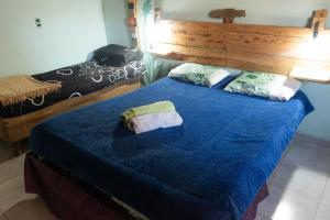 a bedroom with two beds with a blue bedspread at Acusi Hostel Camping in Humahuaca