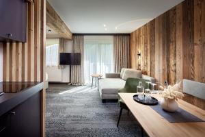 ein Wohnzimmer mit einem Sofa und einem Tisch in der Unterkunft Hotel Gasthof Siggen in Neukirchen am Großvenediger
