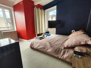 1 dormitorio con paredes rojas y azules y 1 cama en jolie petite maison de bourg en Sayat