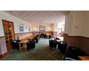 una sala de espera con mesas y sillas en un edificio en Richmond Hotel, en Torquay