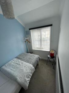 a small bedroom with a bed and a window at Lovely 3 bed house with patio/bbq in Slades Green
