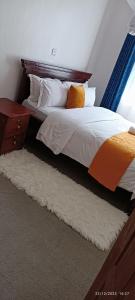 a bedroom with a bed with a wooden headboard at Kai Suites Kitale in Kitale