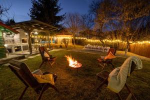 eine Gruppe von Stühlen, die um ein Feuer im Hof herum sitzen in der Unterkunft Zaivan Retreat in Breaza