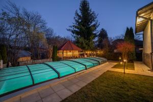 a swimming pool in a backyard at night with lights at Zaivan Retreat in Breaza