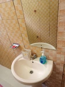 Kai Suites Kitale في كيتالي: حمام مع حوض ومرآة
