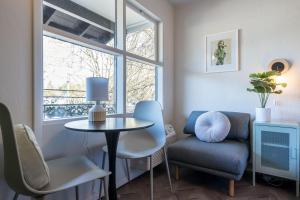 a living room with a table and a chair and a window at The Local Motel & Shops in Eugene