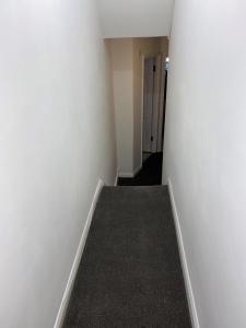 un pasillo vacío con paredes blancas y una escalera en Double Room Near Central London, en Londres