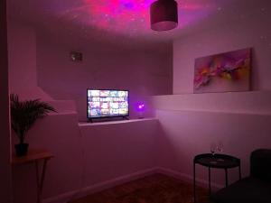 una sala de estar con una habitación púrpura con TV en Double Room Near Central London, en Londres