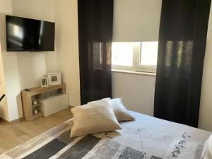 a bedroom with a bed with a flat screen tv at RG MAISON in Morino