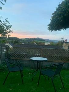 twee stoelen en een tafel in het gras met een tafel bij Mountain views in the heart of Brecon Town in Brecon