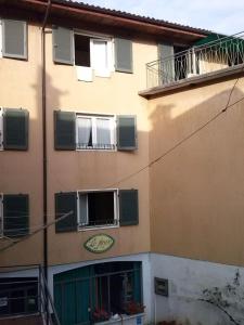 un edificio con ventanas con persianas verdes y un cartel en él en appartamento x 6 persone, en Monasterolo del Castello