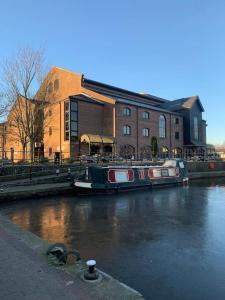 a boat is docked in a river in front of a building at Mountain views in the heart of Brecon Town in Brecon