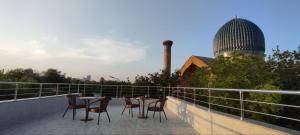 a patio with chairs and tables on a balcony at HOTEL MEHRIBON in Samarkand