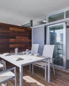 ソトグランデにあるCasa Algo luxe appartement met terras aan zee 133 m2の白いテーブルと白い椅子