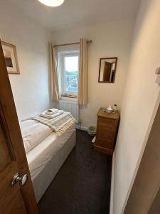 a small bedroom with a bed and a window at Mountain views in the heart of Brecon Town in Brecon