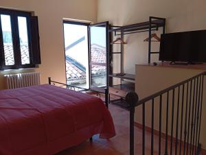 a bedroom with a bed and a flat screen tv at La casa di B in Paganica