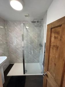 a bathroom with a shower with a glass door at Mountain views in the heart of Brecon Town in Brecon