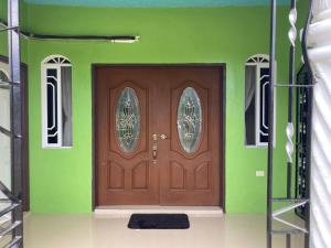 a brown door in a green wall with a black rug at Blissful Retreat in Gravel Hill 