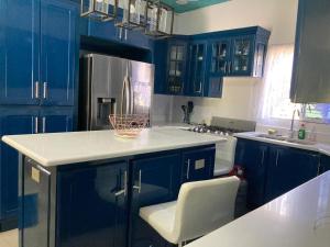 uma cozinha com armários azuis e um balcão branco em Blissful Retreat in Gravel Hill 