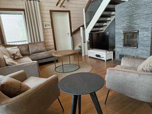 a living room with two couches and a tv at Rantatähti Villa in Syöte