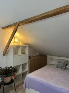 a attic bedroom with a bed and a shelf at Lawendowa Sonata in Nowe Miasto