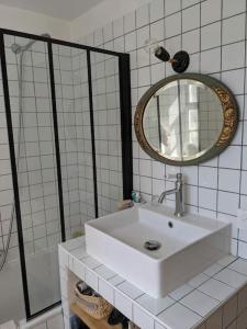 uma casa de banho branca com um lavatório e um espelho em Villa provençale Stella Maris em Toulon