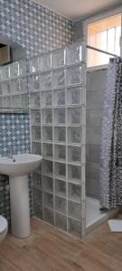 ein Badezimmer mit Waschbecken und einer Glasbausteinwand in der Unterkunft El Cachorro in San Miguel de Abona