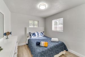 a bedroom with a bed with a blue comforter and two windows at Game Room, Private Pool South Daytona Home! in South Daytona +30 photos