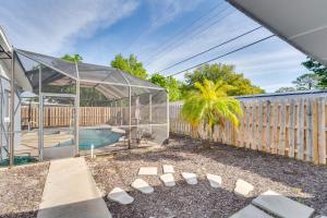 a glass house with a pool and a palm tree at South Daytona Home Game Room, Private Pool! in South Daytona