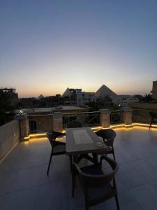 a patio with a table and chairs on a roof at lsis pyramids view in Cairo