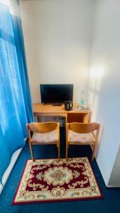 a desk with two chairs and a computer in a room at Maccaroni Restaurants & Hotels in Meiningen