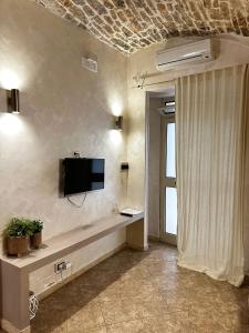 ein Wohnzimmer mit einem TV an der Wand in der Unterkunft B&B PIETRA VIVA in Sannicandro di Bari