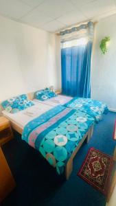 1 dormitorio con 1 cama grande y edredón azul en Maccaroni Restaurants & Hotels en Meiningen