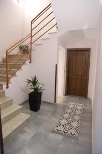 a hallway with stairs and a door with a potted plant at DEAL Castle View Rooms in Krujë
