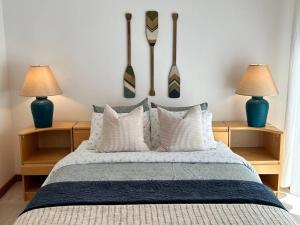 a bedroom with a bed with pillows and two lamps at Seaside Oasis Oceanfront Bliss Condo at Semiahmoo in Blaine