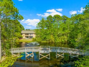 a bridge over a river with a house in the background at Cassine Gardens by Panhandle Getaways in Santa Rosa Beach +14 photos