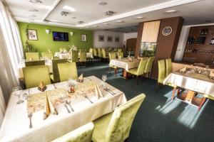 un restaurant avec des tables blanches et des chaises jaunes dans l'établissement Hotel Malina***, à Ružomberok