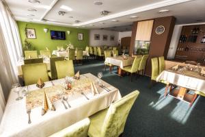 a restaurant with white tables and yellow chairs at Hotel Malina*** in Ružomberok