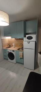 a kitchen with a white refrigerator and a sink at Descanso en el pirineo in Villanúa