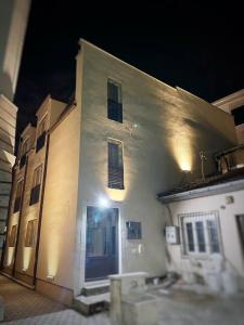 Arasta Apartments في إسكوبية: مبنى أبيض مع باب أزرق في الليل