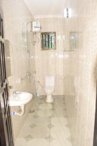 a bathroom with a toilet and a sink at Two Bedrooms Apartment Moshi in Bunju