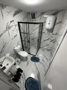 a bathroom with marble walls and a toilet and a sink at Arasta Apartments in Skopje