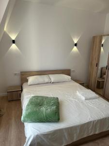 a bedroom with a bed with a green pillow on it at Arasta Apartments in Skopje